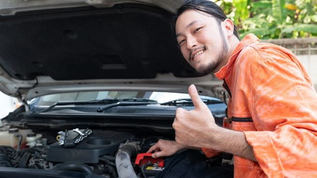 Car maintenance checklist car repairs man in orange shirt charging car battery